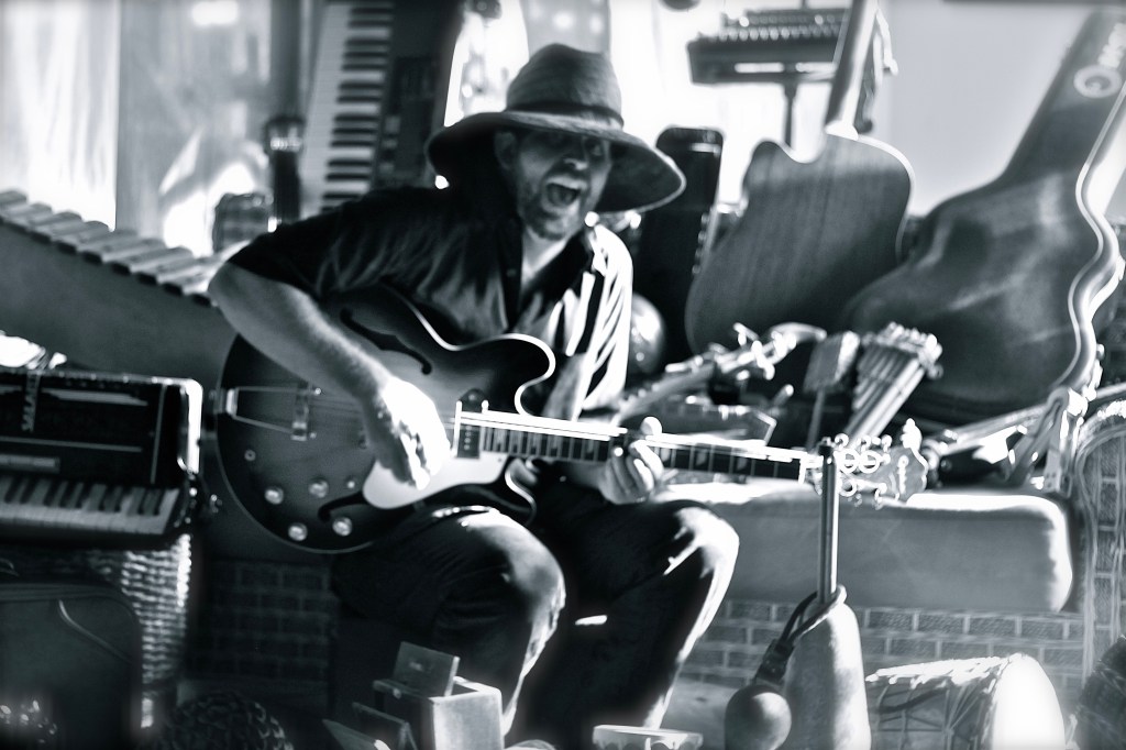 Musician, Artist, Singer, Instrumentalist, Guitar, Ukelele, Piano, Keyboard, Organs, Bass, Drum, Couch, Chair, Stool, Hat, Music, Song, Monochrome