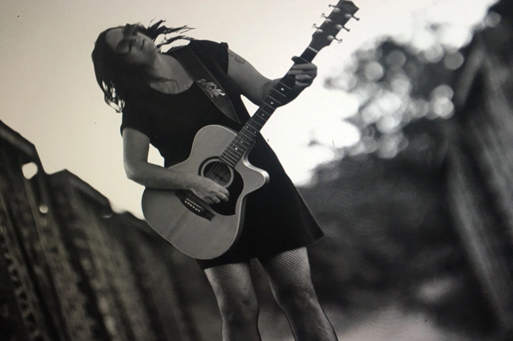 Woman, Emblem, Guitar, Acoustic, Folk. Indie, Black, White, Dress, Monochrome, Sky, Cloud, Trees, Shades, Sunglasses, Stockings, Music, Musician, Artist, Singer, Song