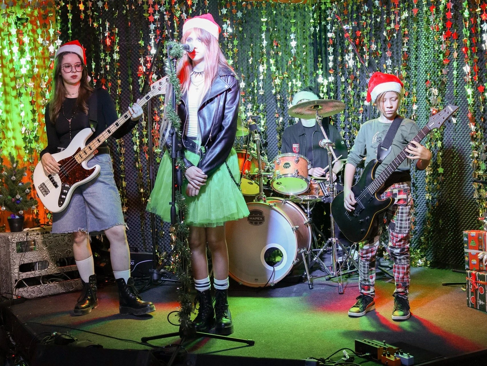 Women, Drums, Mic, Stand, Guitar, Rock, Performing, Concert, Stage, Christmas, Song, Bassist, Drummer, Singer, Music, Leather Jacket, Santa, Hat, Gifts, Holiday, Festive, Speaker, Equipment